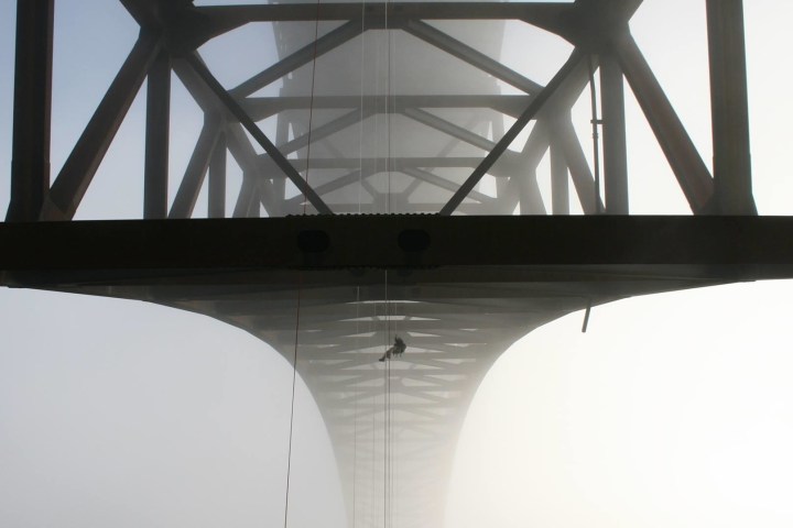 Silhouette of a bridge with fog obscuring the background.